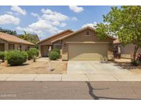 Tan home featuring a two-car garage, a well-kept front yard, and a desert landscape design at 3248 W Sunshine Butte Dr, San Tan Valley, AZ 85144