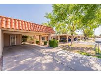 Charming home exterior featuring a spacious carport, vibrant green trees, and a well-maintained lawn at 602 E Colgate Dr, Tempe, AZ 85283
