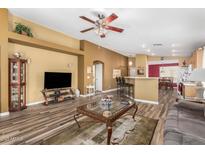 Cozy living room featuring wood-look tile floors, neutral walls, and a ceiling fan at 7003 S 23Rd Ln, Phoenix, AZ 85041
