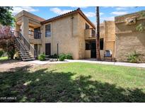 Charming two-story condo with stucco exterior, stairs to upper units, and a well-maintained grassy yard at 8202 N 21St Dr # B101, Phoenix, AZ 85021