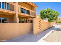 Inviting two-story condo featuring neutral stucco, upper balcony, and decorative privacy walls at 8414 N Central Ave # C, Phoenix, AZ 85020