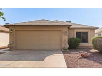 Charming single story home showcasing a two-car garage and low maintenance desert landscaping at 8566 N 110Th Ave, Peoria, AZ 85345