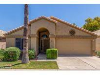 Charming single-story home featuring a well-maintained yard, arched entryway, and a two-car garage at 14561 W Winding Trl, Surprise, AZ 85374