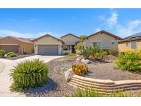 Charming home featuring beautiful desert landscaping, a two-car garage and well-maintained exterior at 20082 N 272Nd Ln, Buckeye, AZ 85396
