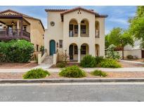 Charming two-story home featuring arched entryways, balconies, and a well-manicured front yard at 2854 N Claire Dr, Buckeye, AZ 85396