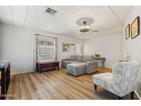 Living room featuring gray sofa, wood-look floors, and natural light at 4065 E University -- # 433, Mesa, AZ 85202