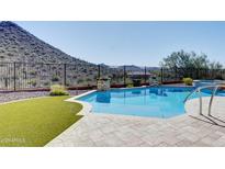 Inviting backyard pool surrounded by desert landscape, perfect for relaxation and outdoor enjoyment at 42101 N Olympic Fields Ct, Anthem, AZ 85086