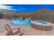 A gorgeous pool and spa are surrounded by desert landscaping and have mountain views at 42101 N Olympic Fields Ct, Anthem, AZ 85086