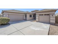 Inviting single-story home showcasing a tandem three-car garage and low-maintenance desert landscaping at 43205 W Oster Dr, Maricopa, AZ 85138