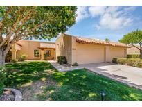 Inviting home with a two-car garage, well-maintained lawn, and mature shade trees on a sunny day at 713 W Boxelder Pl, Chandler, AZ 85225