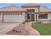 Charming single-story home featuring a two-car garage, tiled roof, and inviting walkway at 7344 E Flower Ave, Mesa, AZ 85208