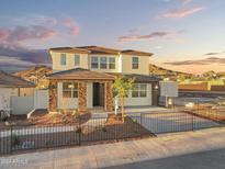 Inviting two-story home featuring stone accents, a charming front yard, and a cozy covered entryway at 7392 W Buckhorn Trl, Peoria, AZ 85383
