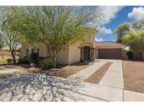 Charming home featuring desert landscaping, a quaint front entrance, and a long driveway leading to a two-car garage at 897 E Cherry Hills Dr, Chandler, AZ 85249