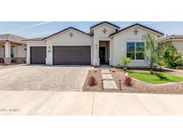 Charming home featuring a three-car garage, landscaped yard, and inviting walkway at 10447 W Salter Dr, Peoria, AZ 85382