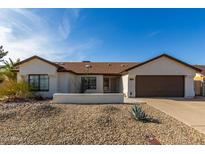 Charming single-story home featuring a xeriscaped front yard and an attached two-car garage at 13918 N 78Th Ave, Peoria, AZ 85381