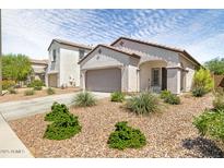 Charming single-story home featuring a low-maintenance desert landscape and a two car garage at 19664 W Woodlands Ave, Buckeye, AZ 85326