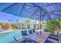 Relaxing backyard featuring a sparkling pool and shaded patio area, perfect for outdoor entertaining at 2046 E Downing St, Mesa, AZ 85213