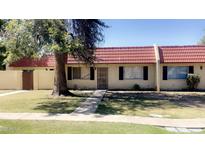Charming exterior view of home, featuring a red tile roof and a cozy front yard with mature tree at 3404 W Tangerine Ln, Phoenix, AZ 85051