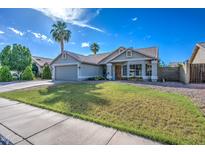 Charming single-story home featuring a well-maintained lawn, desert landscaping and a two car garage at 4050 E Encinas Ave, Gilbert, AZ 85234