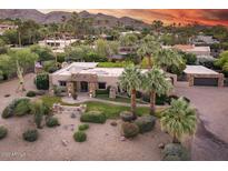 Expansive home with stone accents, mature landscaping, and a detached garage on a tree filled lot at 4836 E Moonlight Way, Paradise Valley, AZ 85253