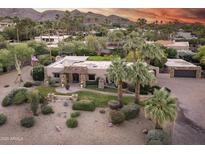 Stunning property featuring lush landscaping, a stone facade, barrel tile roof and mountain views at 4836 E Moonlight Way, Paradise Valley, AZ 85253