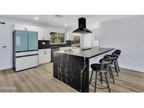 Modern kitchen boasts black countertops, black backsplash, stainless steel appliances and a black exhaust hood at 5728 E Sharon Dr, Scottsdale, AZ 85254