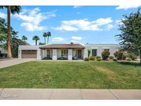 Charming single-story home featuring a well-manicured lawn and desert landscaping at 8034 E Del Caverna Dr, Scottsdale, AZ 85258