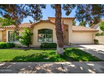 Charming single-story home with a well-manicured lawn, two-car garage, and a welcoming arched entryway at 9575 S Ash Ave, Tempe, AZ 85284