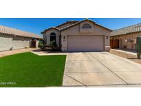 Charming single-story home with a neutral color palette, well-manicured lawn, and two-car garage at 15231 W Melissa Ln, Surprise, AZ 85374