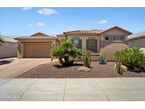 Charming single-story home featuring desert landscaping, a tile roof, and an attached two-car garage at 18242 W Stinson Dr, Surprise, AZ 85374