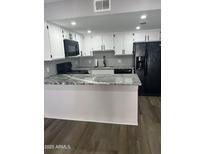 Updated kitchen with stainless steel appliances, granite counters, and white cabinets at 2144 E Center Ln # 3, Tempe, AZ 85281