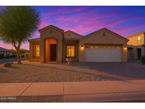 Charming single-story home featuring a two-car garage, desert landscaping, and a covered entryway at dusk at 3438 W Little Hopi Dr, Phoenix, AZ 85086