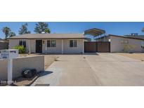 Charming single-story home featuring a covered carport and a well-maintained front yard at 4025 E Surrey Ave, Phoenix, AZ 85032