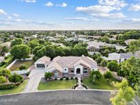 Expansive single-story home featuring a lush green lawn, mature trees, a tile roof, and an attached three car garage at 4040 E Mclellan Rd # 16, Mesa, AZ 85205