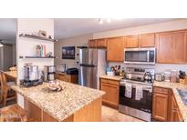 Well-lit kitchen features stainless steel appliances and a beautiful granite countertop island at 455 S Mesa Dr # 104, Mesa, AZ 85210