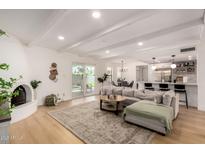 Bright, open-concept living room with wood floors, fireplace, kitchen and access to a backyard pool at 6835 E Friess Dr, Scottsdale, AZ 85254