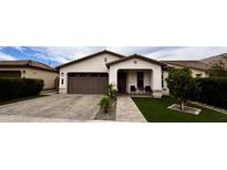 Charming single-story home with a well-manicured lawn, inviting entryway and a two car garage at 6947 W Spur Dr, Peoria, AZ 85383