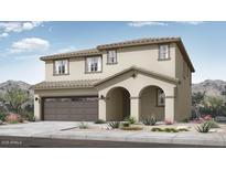 A charming two-story home features a two-car garage and front yard landscaping at 14394 W Calle Lejos --, Surprise, AZ 85387