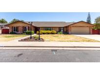 Charming single-story brick home with a well-maintained lawn and manicured landscaping at 1735 E Hope St, Mesa, AZ 85203