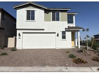 Charming two-story home with a white exterior, a two-car garage, and a well manicured front yard at 18001 W Lupine Ave, Goodyear, AZ 85338