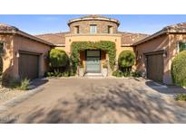 Inviting front entrance with arched greenery and matching topiaries flanking the glass front door at 18127 N 98Th Way, Scottsdale, AZ 85255
