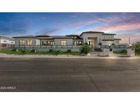 Striking modern home with clean lines, a manicured front yard, and a multi-level roofline against a vibrant sky at 3653 E Runaway Bay Pl, Queen Creek, AZ 85142