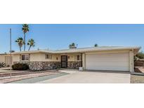 Charming single-story home with stone accents, desert landscaping, and an attached two-car garage at 6051 E Ensenada St, Mesa, AZ 85205