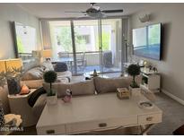 Cozy living room featuring a couch, TV, and a sliding glass door to a balcony at 7625 E Camelback Rd # B241, Scottsdale, AZ 85251