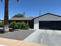 Charming single-story home with well-maintained landscaping, a new garage door, and a quaint front yard at 7802 E Hubbell St, Scottsdale, AZ 85257