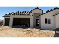 Exterior view of new construction with two-car garage with the roofing being installed at 9429 W Sandstone Mountain Dr, Casa Grande, AZ 85194