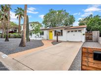 Charming home with a yellow door, manicured yard, and brick accents at 1233 E El Camino Dr, Phoenix, AZ 85020