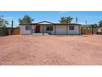 Charming single-story home features a red front door, metal overhang, and a gravel front yard for low maintenance appeal at 12810 N 20Th St, Phoenix, AZ 85022