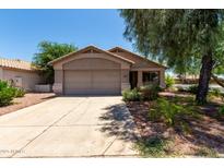 Charming single-story home featuring a two-car garage and desert landscaping at 13861 W Elm St, Surprise, AZ 85374