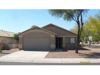 Charming single-story home featuring a well-maintained front yard and attached two-car garage at 13861 W Elm St, Surprise, AZ 85374